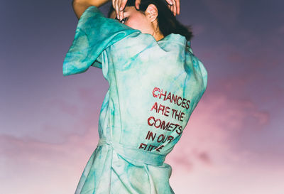 Low angle view of woman standing against sky