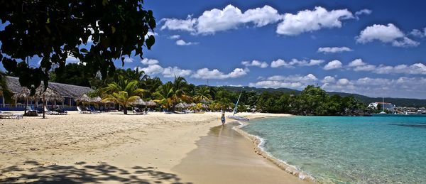 Scenic view of beach against cloudy sky