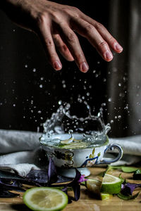 Hand above splashing cup of water