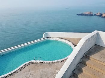High angle view of swimming pool by sea against sky