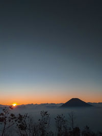 Scenic view of silhouette mountains against sky at sunset