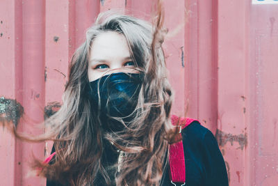 Portrait of woman with fair hair against red wall