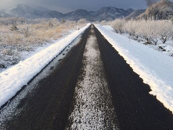 Empty road on snow covered field