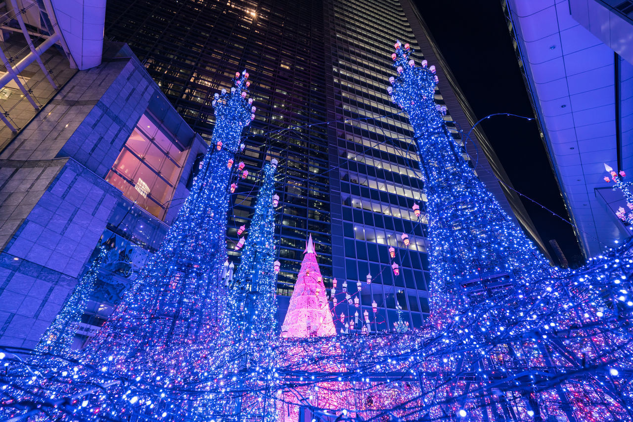 LOW ANGLE VIEW OF ILLUMINATED BUILDING IN CITY AT NIGHT