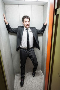 Full length portrait of a young man standing at home