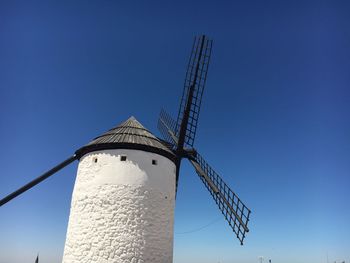 Low angle view of windmill against clear blue sky