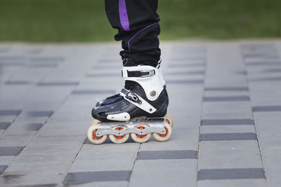 Low section of person wearing shoes on footpath