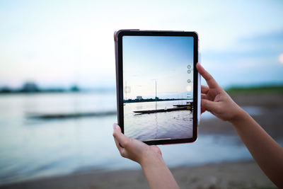 Cropped hands of woman using digital tablet