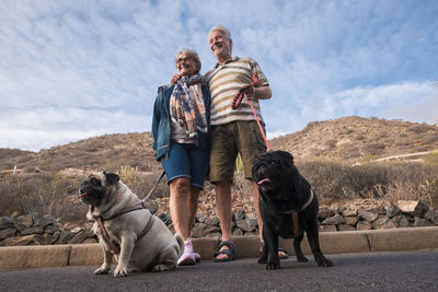 Senior couple with dogs on road