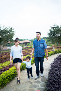 Portrait of smiling couple walking on field