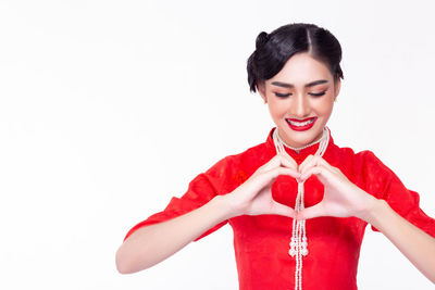 Portrait of a smiling young woman against white background