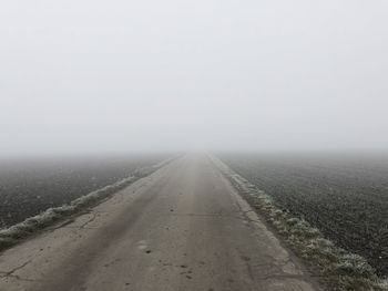 Road in foggy weather against sky during winter