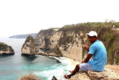 Man sitting on rock looking at view