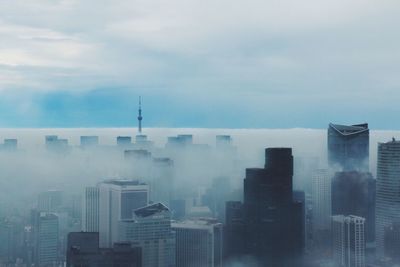 Skyscrapers against cloudy sky