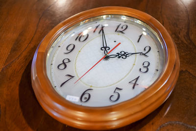 Close-up of clock on wooden wall