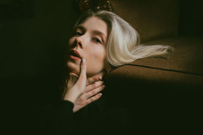 Portrait of beautiful young woman against black background