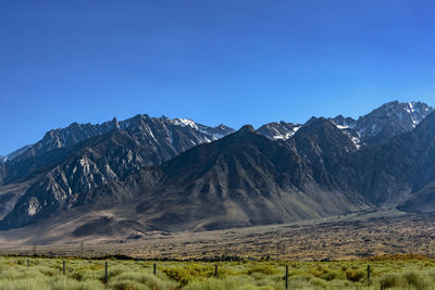 Scenic view of snowcapped mountains against clear blue sky