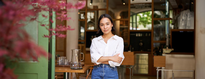 Portrait of young woman standing in city