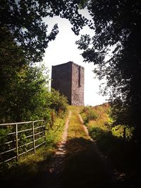 Footpath amidst buildings against sky