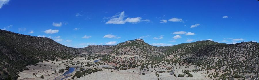 Panoramic view of mountains against blue sky