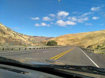 Road against sky seen through car windshield