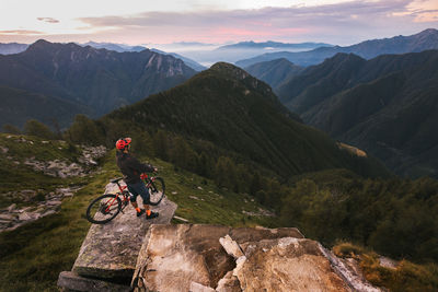 Man riding bicycle on mountain against sky