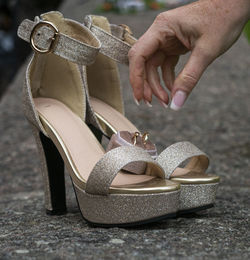 Close-up of hand holding leather shoes