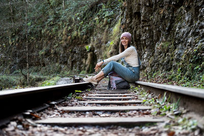 Woman sitting on railroad track