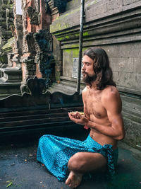 Shirtless man sitting in temple