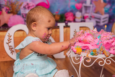 Messy baby eating birthday cake