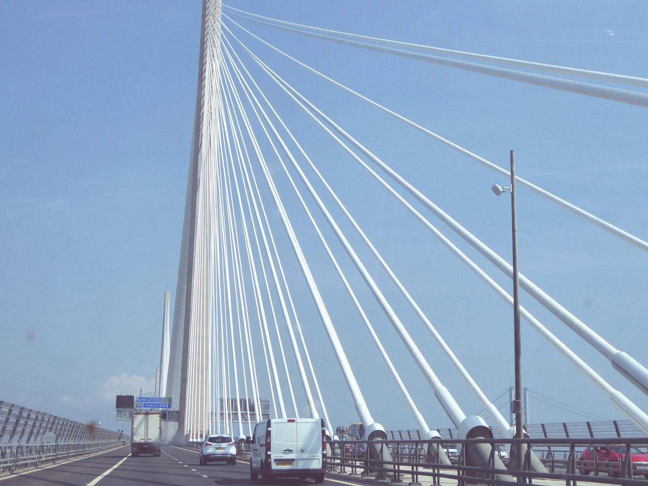 transportation, mode of transportation, sky, architecture, built structure, bridge, bridge - man made structure, cable-stayed bridge, connection, motor vehicle, land vehicle, car, suspension bridge, day, nature, engineering, blue, city, road, outdoors