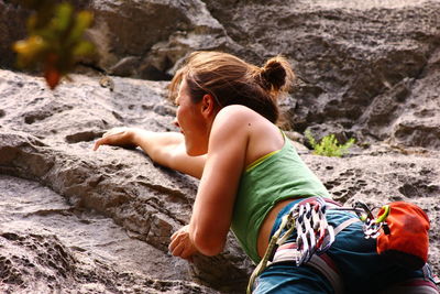 Low angle view of woman climbing rock