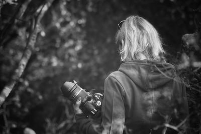 Rear view of woman photographing outdoors