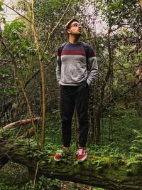 Portrait of young woman standing in forest