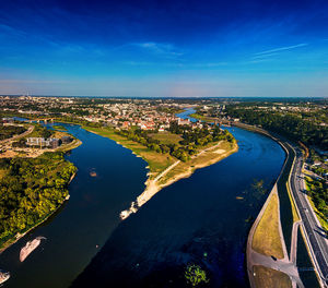 High angle view of river amidst city against blue sky