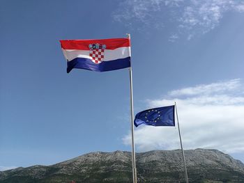 Low angle view of flag against blue sky