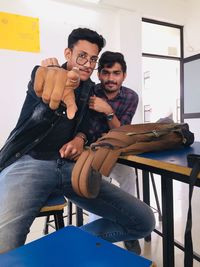 Young man using mobile phone while sitting on table