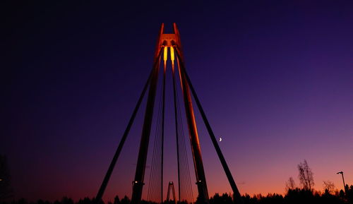 Low angle view of illuminated bridge against sky at sunset