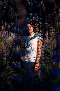 Portrait of young woman looking away in forest