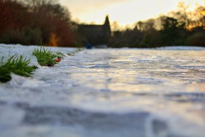 Surface level of frozen water against sky