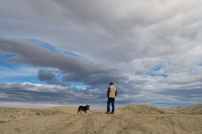 Rear view of woman with dog on beach