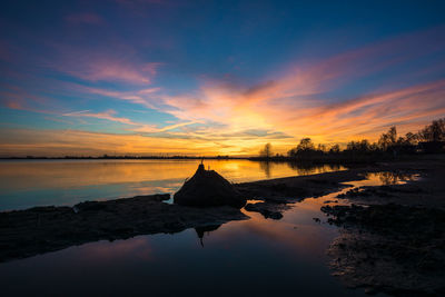 Scenic view of lake against sky during sunset