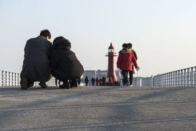 People on street against sky in harbor 