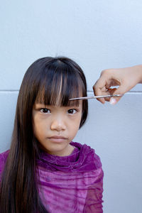 Close-up portrait of cute girl against wall