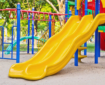 View of yellow outdoor play equipment in park
