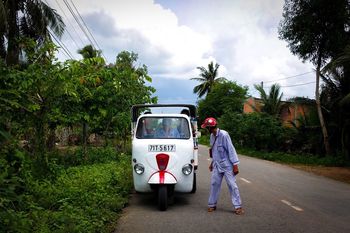 REAR VIEW OF MAN CYCLING ON ROAD