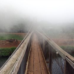 Hanapepe swinging bridge over river during foggy weather