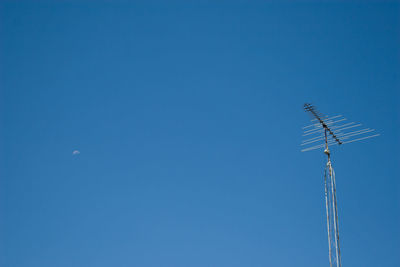 Low angle view of windmill against clear blue sky