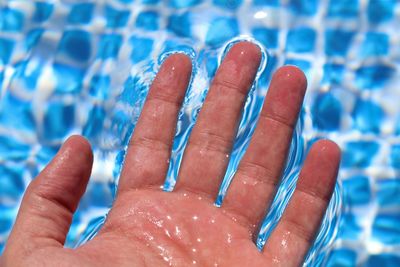 Cropped hand on swimming pool