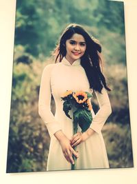 Portrait of beautiful woman standing against white wall